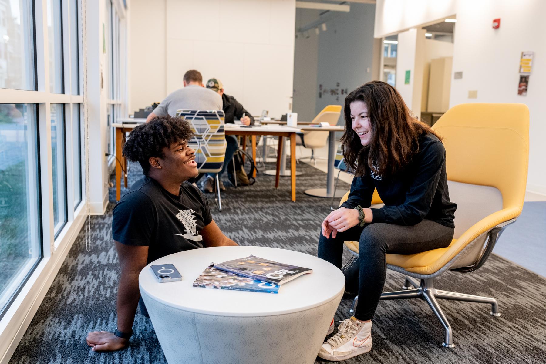 Two trinity college students conversing in a study lounge